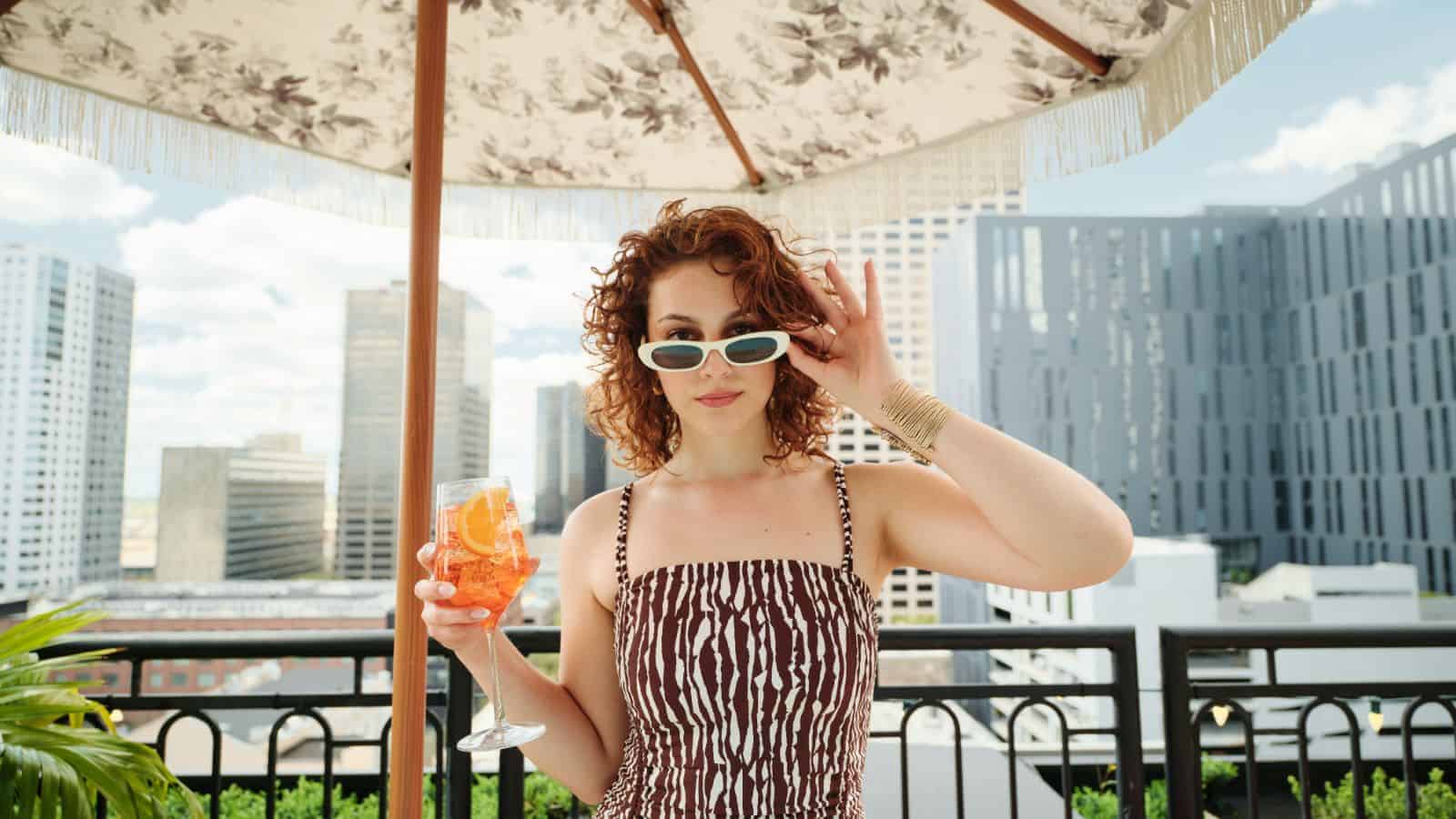 I Thought I Missed My Chance at a Summer Vacation. Then I Discovered These Last-Minute Deals 8 woman sunglasses on hotel rooftop virgin hotels