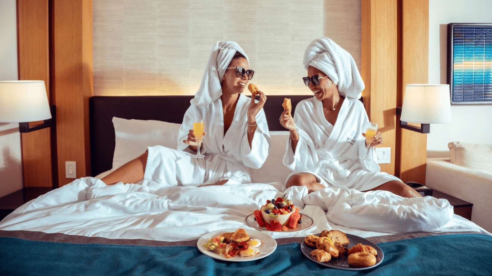 Romantic Destinations Perfect for a Last‑Minute Valentine’s Getaway 30 Sonesta Resorts St. Maarten – St. Maarten women in bed eating_1