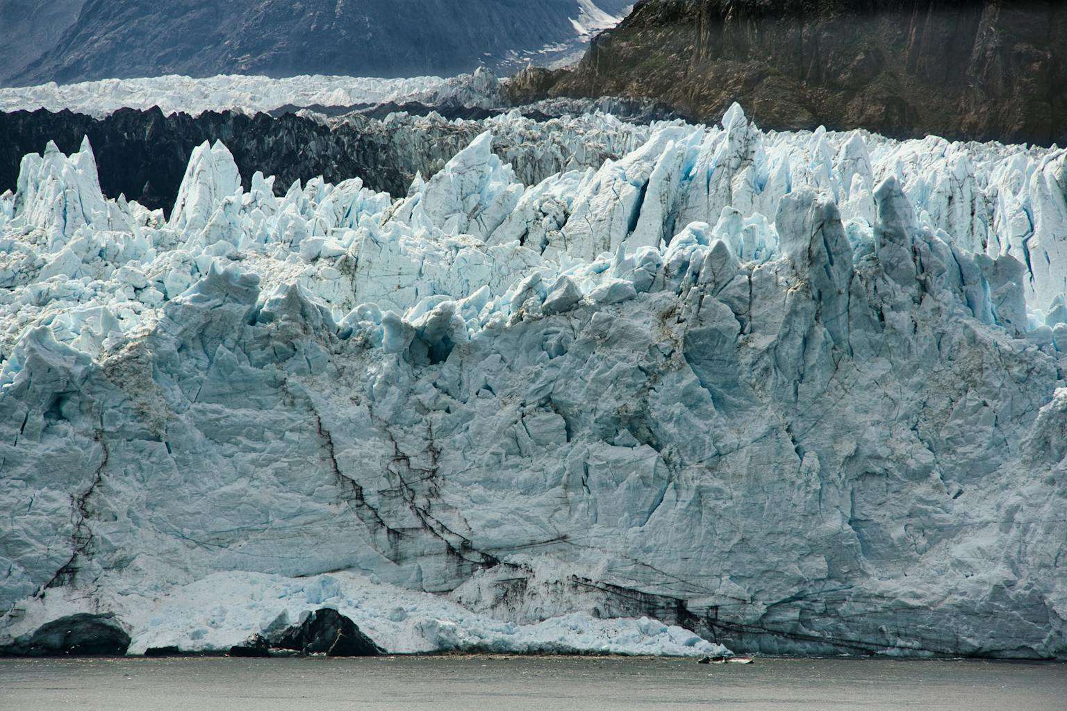 20 American Disaster Towns Forever Marked by One Terrifying Day 16 A breathtaking view of a massive glacier in Alaska, showcasing its icy formations and rugged beauty.