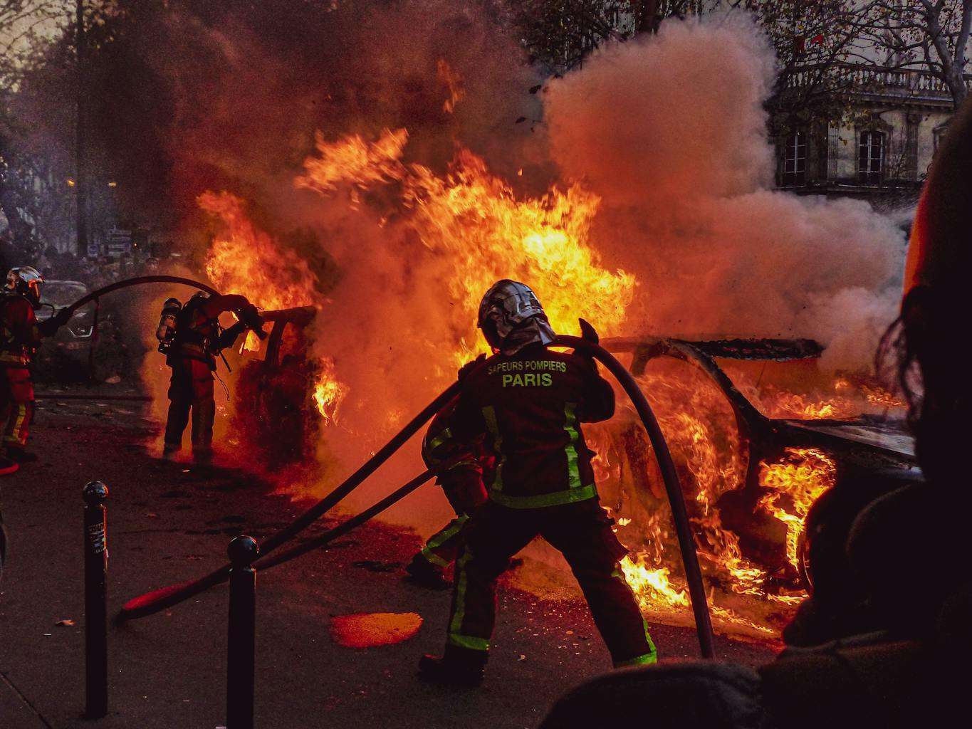 20 American Disaster Towns Forever Marked by One Terrifying Day 15 Firefighters extinguishing a blazing car fire on Paris streets during an emergency response.